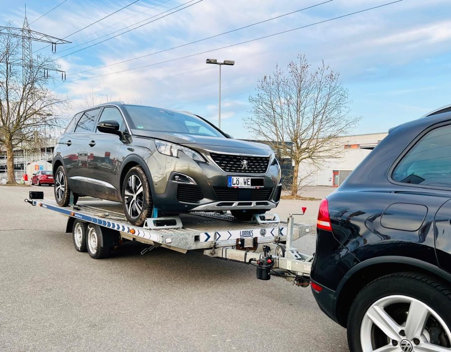 Transport von Defektfahrzeugen & Unfallwagen Sicherer Transport eines defekten Pkw auf einem Autoanhänger.
